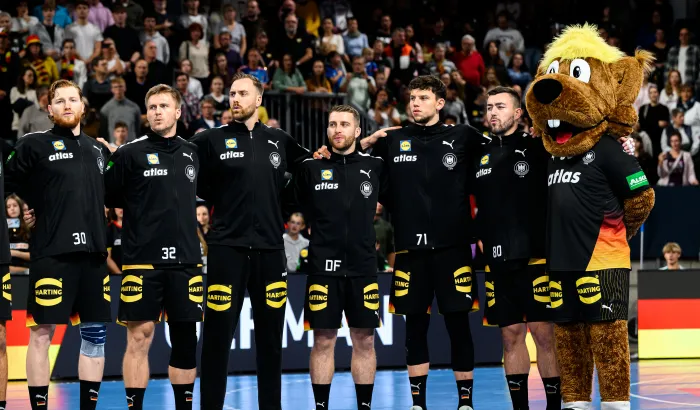 Männer-Nationalmannschaft Handball bei der Hymne mit Maskottchen.