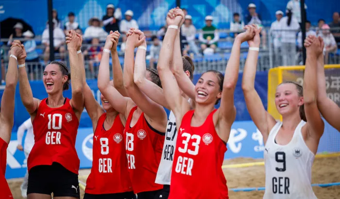 Eine Gruppe von jungen Frauen in roten Oberteilen jubeln zusammen