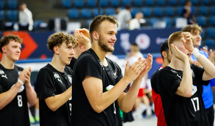 Eine Truppe von Männern in schwarzen Trikots die jubeln und klatschen