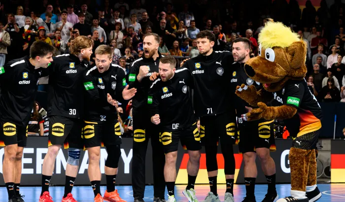 Deutsche Handball-Männer-Nationalmannschaft steht zusammen in einer Reihe und jubelt sich zu.