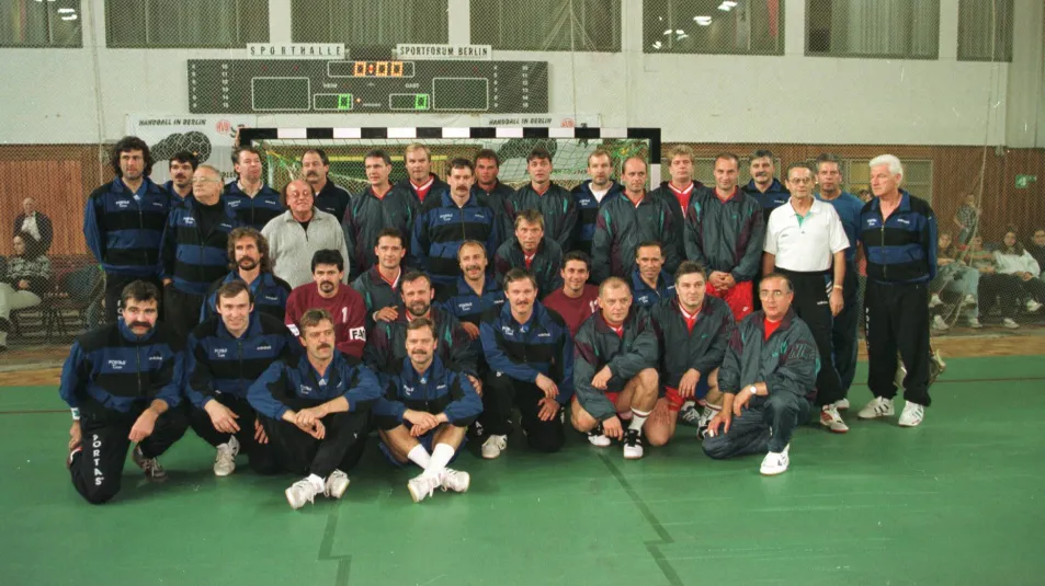 Eine Handballmannschaft die zusammen für ein Foto im Tor steht. 