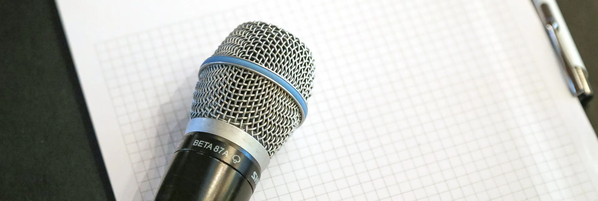 Ein Mikrofon liegt auf einem Papierblock