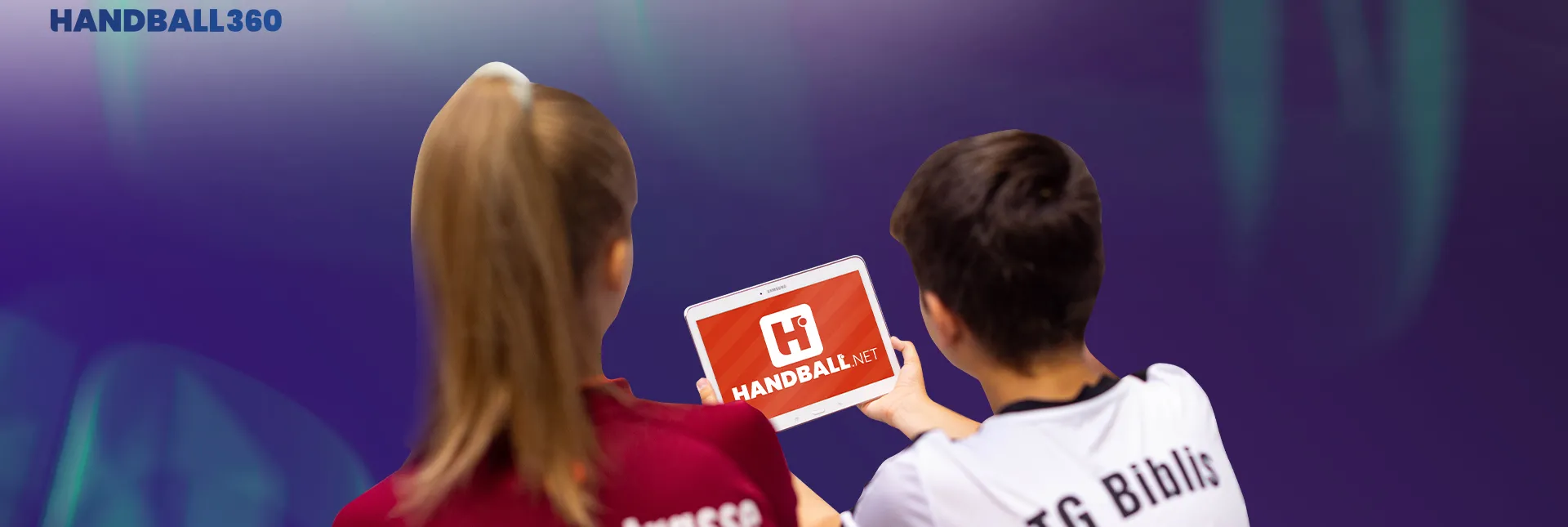 Zwei Handballer/innen blicken auf das neue handball.net