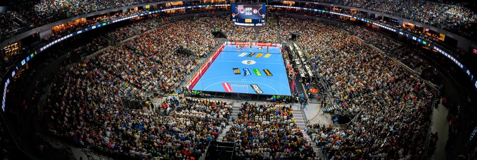 Blick von oben in den gefüllten Innenraum der Lanxess arena bei einem Handballspiel.