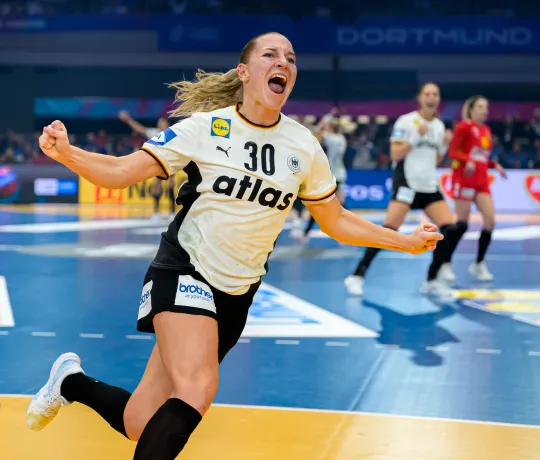 Handballspielerin jubelt nach Tor auf dem Feld