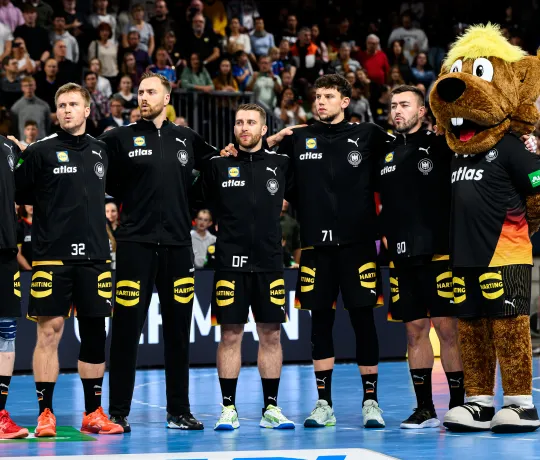 Männer-Nationalmannschaft Handball bei der Hymne mit Maskottchen.