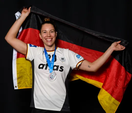 Eine Handballerin mit einer Deutschlandfrage am jubeln.  