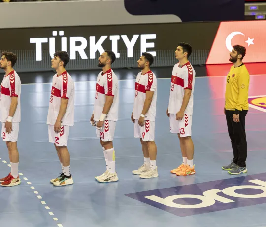 Türkische Handball-Nationalmannschaft singt die Hymne vor einem Handballspiel.