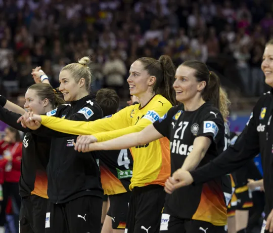 Eine Truppe Frauen die zusammen jubeln und die Hände in die Luft strecken. 