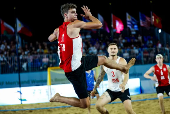 Beachhandballer setzt zum Wurf an