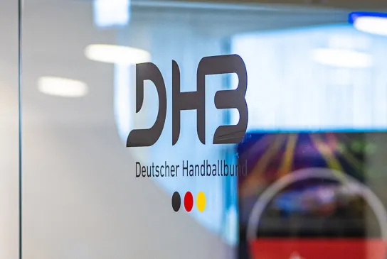 Das DHB Logo klebt auf einer Scheibe