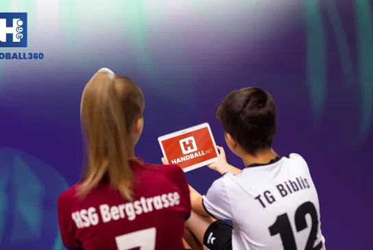 Zwei Handballer/innen blicken auf das neue handball.net