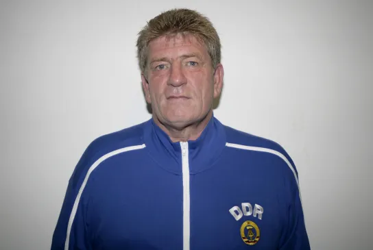 Ein Porträtfoto eines Mannes in blauer Jacke mit DDR auf der Brust