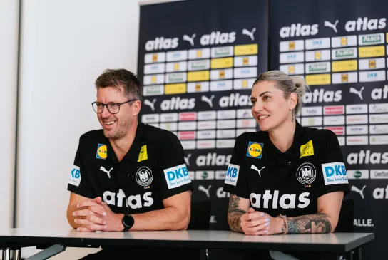 Ein Mann und eine Frau die nebeneinander sitzen und Lachen. 